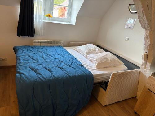 a small bedroom with a bed with a blue blanket at Appartement piscine cure thermale in La Roche-Posay