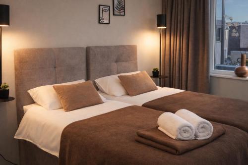 two beds in a hotel room with towels on them at Modern Suite with AC near Breda & Efteling in Raamsdonksveer