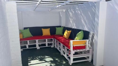 a bench with colorful pillows sitting in a pergola at Marina Dreams Studio Apartment in Marina Da Gama