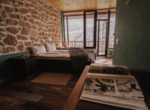 a room with a bed and a stone wall at Gnishik Eco Lodge in Gnishik