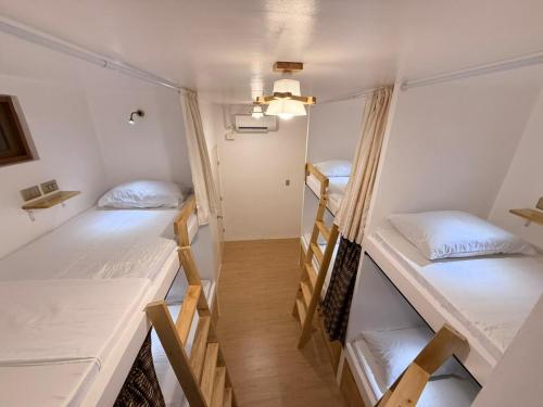 a room with three bunk beds in it at AMIGOS Hostel El Nido in El Nido