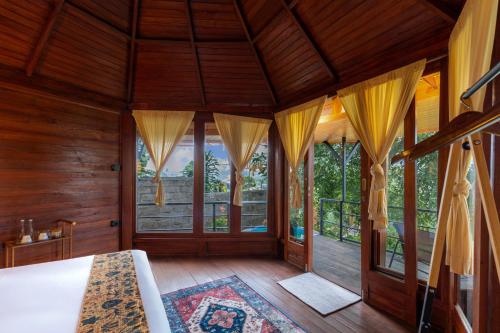 ein leerer Raum mit Holzwänden und Fenstern in der Unterkunft Alamu Eco Lodge in Bedugul