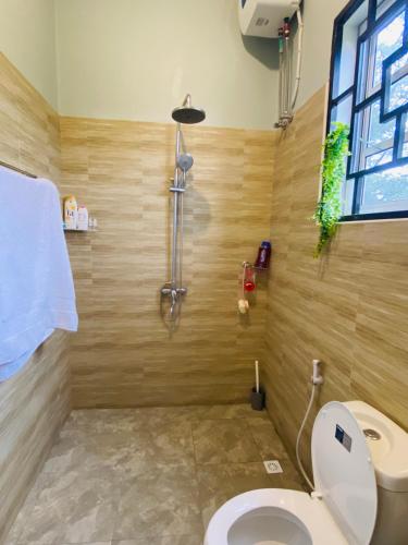 a bathroom with a toilet and a shower at Tulivu Nyumba in Arusha
