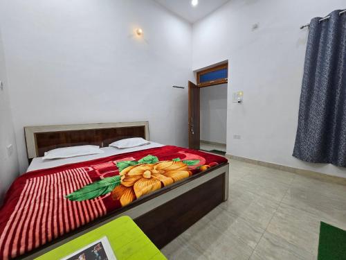 a bedroom with a bed with a red comforter at Parth Guest House in Ayodhya