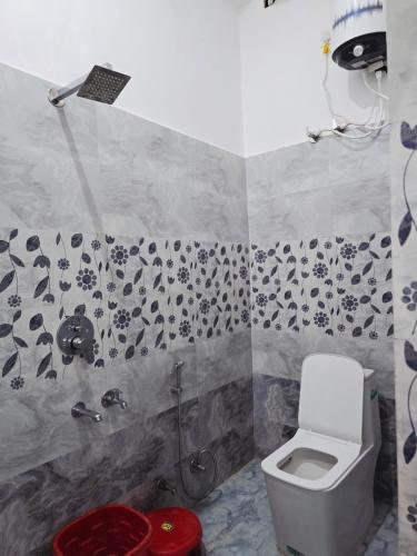 a bathroom with a toilet and a shower at Parth Guest House in Ayodhya