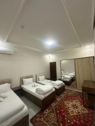 a hotel room with two beds and a mirror at Abu Zarr Terrace in Bukhara