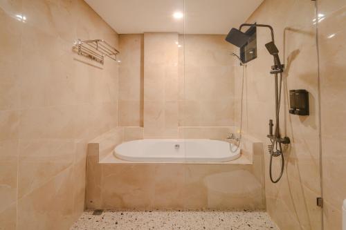 a bathroom with a bath tub and a shower at Mamo Hotel Uluwatu in Uluwatu