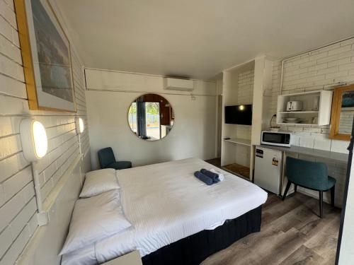 a small bedroom with a bed and a kitchen at Mayfield Motel in Mayfield