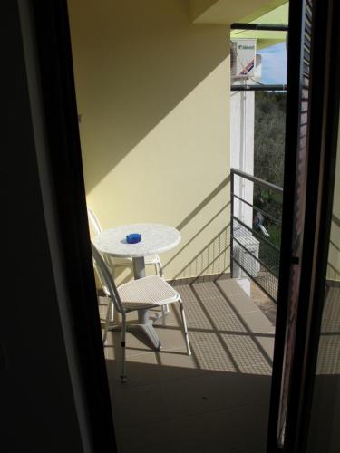 a white table and a chair on a balcony at Apartments and Rooms Degenija in Starigrad-Paklenica