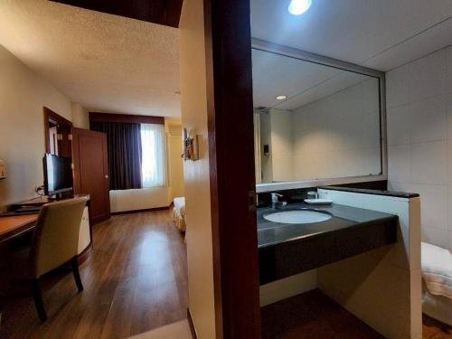a bathroom with a sink and a large mirror at Hatyai Golden Crown Hotel in Hat Yai