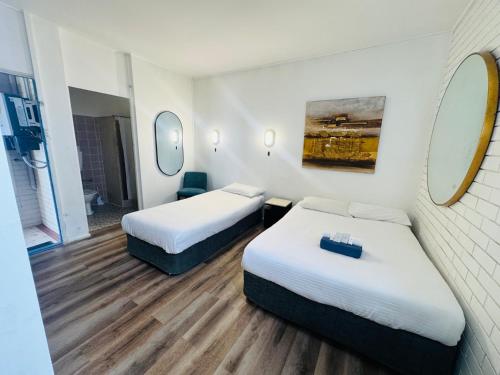 a hotel room with two beds and a mirror at Mayfield Motel in Mayfield