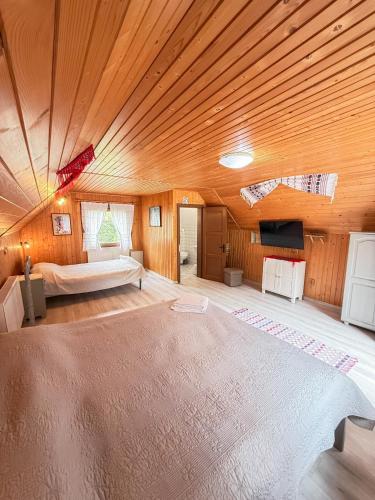 a large bedroom with a bed and a wooden ceiling at Vila Adela in Lacu Rosu
