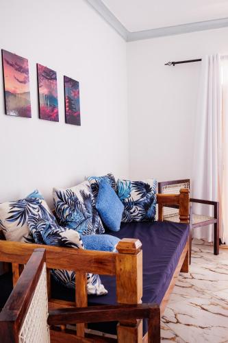 a living room with a couch with blue pillows at Azara Watamu in Watamu