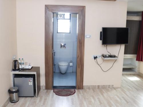 a bathroom with a toilet and a tv in a room at Heritage Tezpur in Tezpur