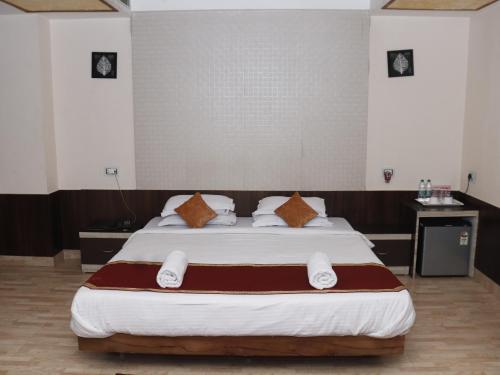 a bedroom with a large bed with brown and white pillows at Heritage Tezpur in Tezpur