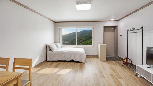 a bedroom with a bed and a large window at Gapyoeng New Cheongpyeong Pension in Gapyeong