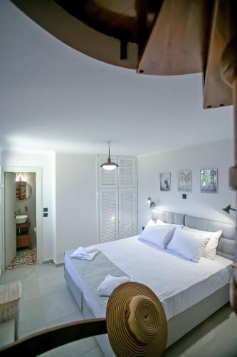 a white bedroom with a large bed and a table at Casa Govino - Dolce fare niente in Danilia