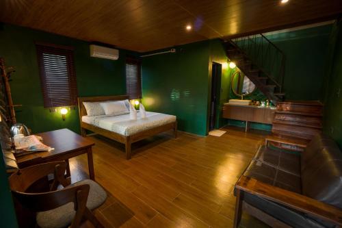 a green room with a bed and a sink at Aran Villas in Santa Maria