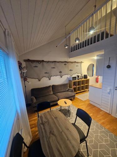 a living room with a table and chairs and a couch at Fisher Loft 30 in Kristiansund