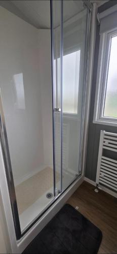 a glass shower in a room with a window at T&K's Caravan in Morecambe