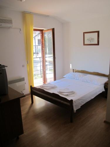 a bedroom with a bed in a room with a window at Apartments and Rooms Degenija in Starigrad-Paklenica