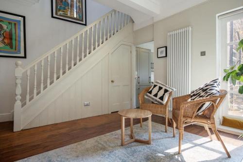 a living room with stairs and chairs and a table at Sycamore House in York