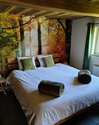 a bedroom with a large bed with a wall with trees at Le Clos du Cerf - Le Sous-bois in Stoumont