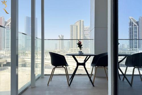 a table and chairs in a room with a view of a city at Chic Modern 1BR - Executive Al Maryah Stay in Abu Dhabi