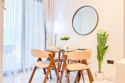 a dining room table with chairs and a mirror at Chic Modern 1BR - Executive Al Maryah Stay in Abu Dhabi