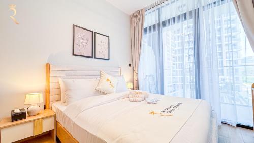 a bedroom with a white bed with a large window at Chic Modern 1BR - Executive Al Maryah Stay in Abu Dhabi