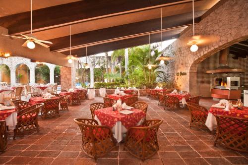 a dining room with red tables and chairs at El Cid Granada Hotel & Country Club in Mazatlán