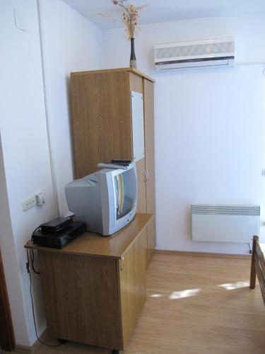 a tv sitting on a wooden stand in a room at Apartments and Rooms Degenija in Starigrad-Paklenica