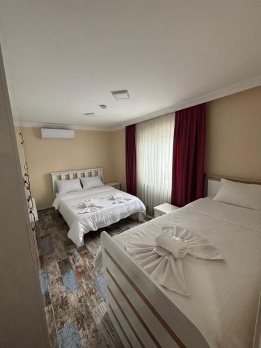 a hotel room with two beds and a window at Çilek Home in Pamukkale