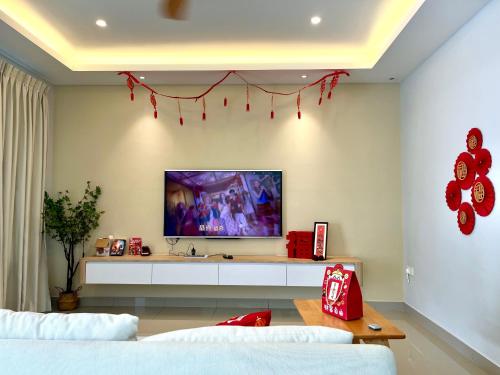 a living room with a tv on a wall at Ayera Residence Muji X Near Permas X Staycation 4BR4B #12 pax by Cowidea in Masai