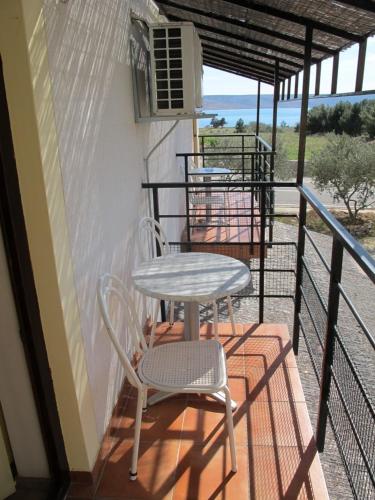 a table and a chair sitting on a balcony at Apartments and Rooms Degenija in Starigrad-Paklenica