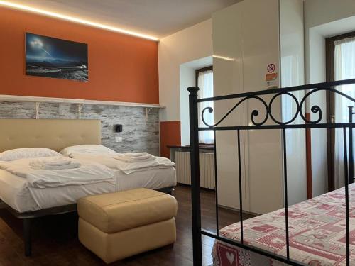 a bedroom with two beds and a chair at HOTEL GARNI BARANCIO - Auronzo center in Auronzo di Cadore