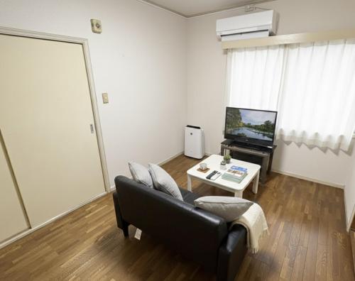 a living room with a couch and a table at RHK Guest House102 in Tokyo