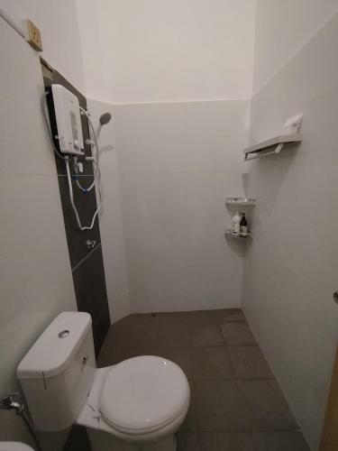a bathroom with a toilet and a phone on the wall at 4 Seasons Homestay in Kuantan