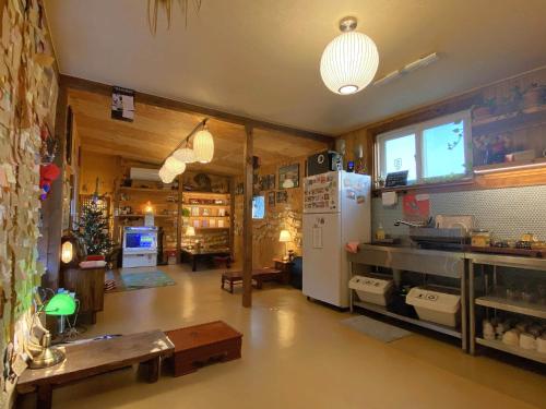 a kitchen with a refrigerator and a table in a room at Architect's Cat Hanok - Sindal House Gyeongju in Gyeongju
