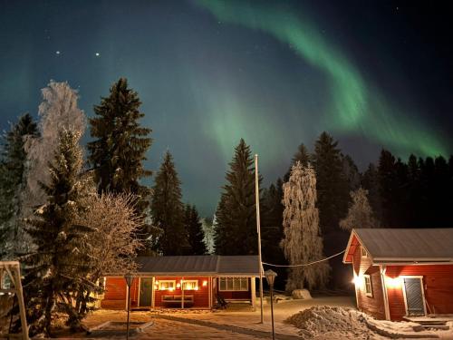 a cabin with the aurora in the sky at Guest cabin, Haukipudas, sauna and free parking in Haukipudas