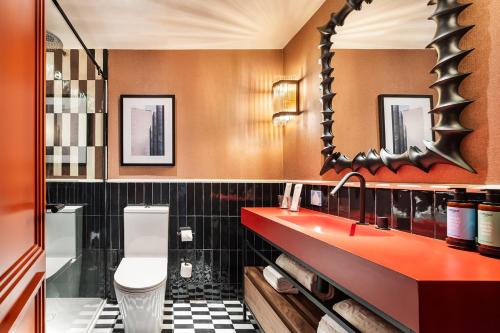 a bathroom with a red sink and a mirror at One Shot La Latina in Madrid