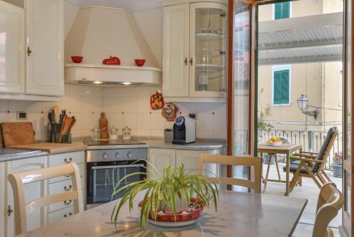 a kitchen with white cabinets and a table with a plant at A Casa di Nonna Anna in Porto Azzurro