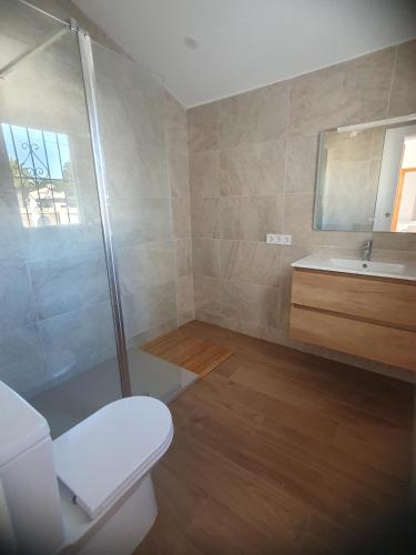 a bathroom with a shower and a toilet and a sink at Chalet Laguna Rosa in Torrevieja