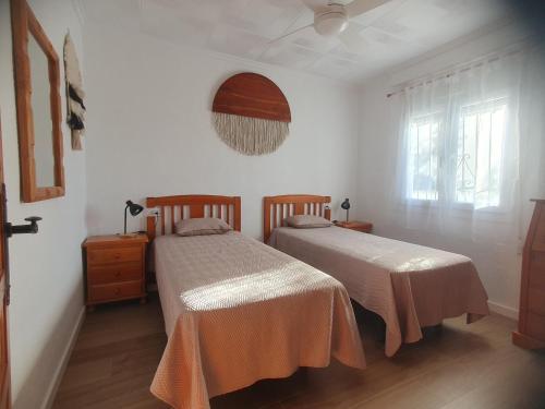 a bedroom with two beds and a window at Chalet Laguna Rosa in Torrevieja