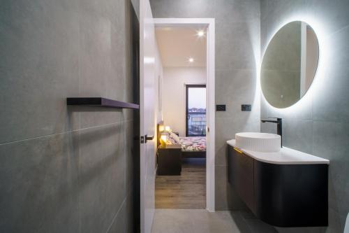 a bathroom with a sink and a mirror at Brand New Elegant House in Marsden Park