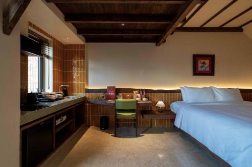 a bedroom with a bed and a desk and a kitchen at Olwen Boutique Hotel in Danang