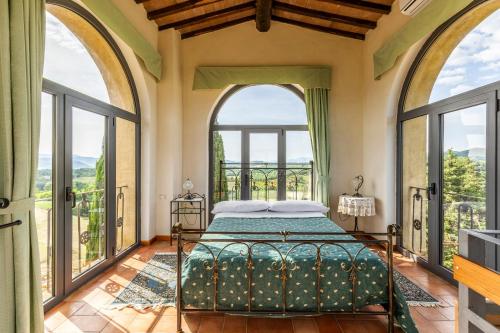 a bedroom with a bed and large windows at "Villa Bizzi" in Monte Castelli