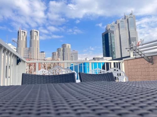 a table and chairs on a balcony with a city skyline at Hotel EL Shinjuku 6 in Tokyo