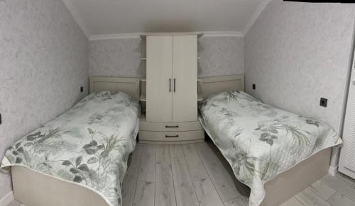 ein Schlafzimmer mit zwei Betten und einem Schrank in der Unterkunft Qax, Agсhay in Ağçay