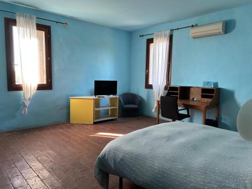 a blue room with a bed and a desk at B&B La Piuma in Castellaccio